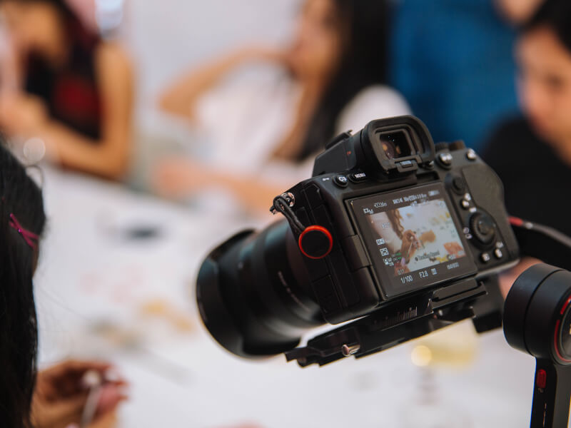 Photo from behind showing someone holding a DSLR camera